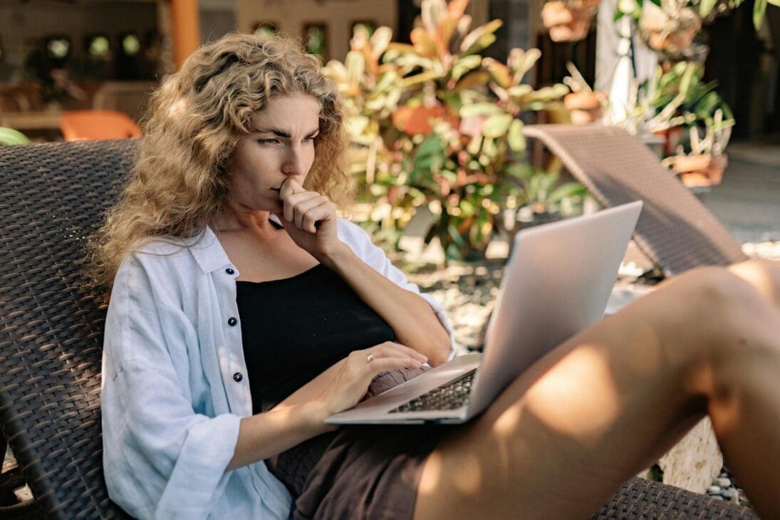 Woman working on her laptop while traveling, showcasing side hustles that still work from anywhere.