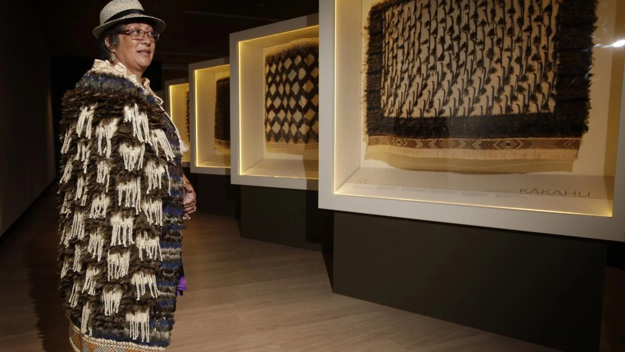 Māori woman wearing a traditional kahu kiwi cloak made from kiwi feathers, representing heritage and cultural guardianship of new zealand culture