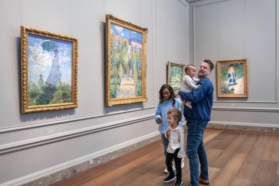 Family enjoying and discussing artwork together in a museum, engaging mindfully with the exhibits.