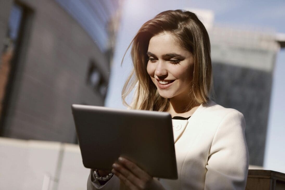 Woman happily reviewing museum photos on her tablet, reflecting on her art visit.
