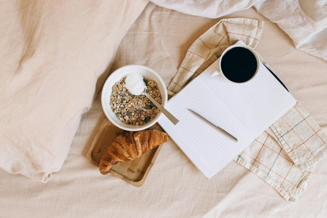 Flat lay of coffee, notebook, and healthy snack showing a balanced café-hopping routine